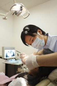 女の子の歯科検診を行う歯科医師